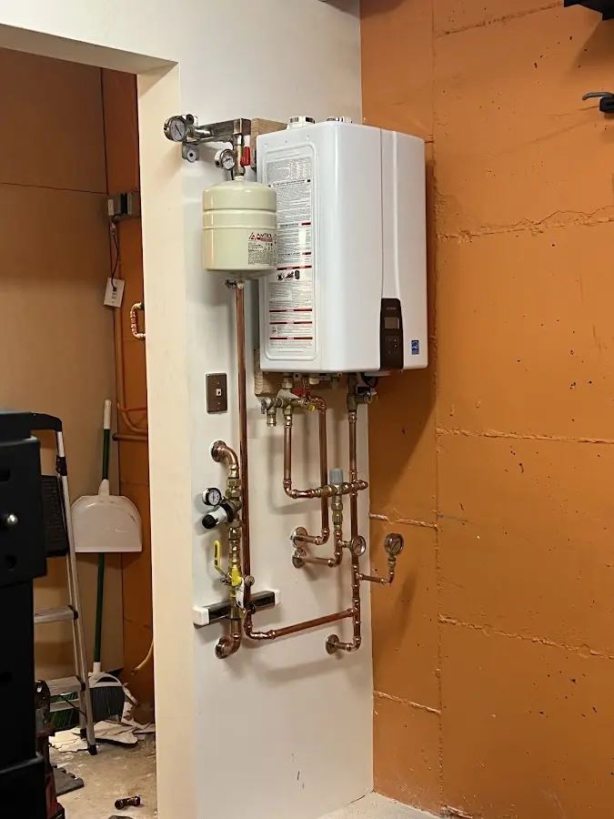Plumbing technician inspecting water heater connections in Bowie